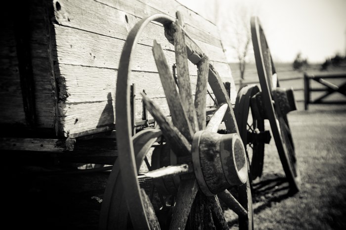 Old wooden wagon wheels leaning against a weathered wagon
