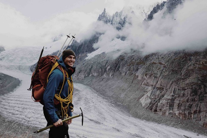 Man with backpack and ice pick on a glacier