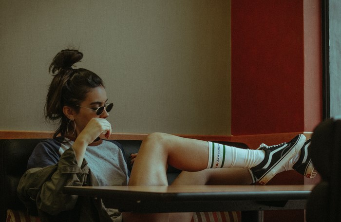 Woman in Vans sneakers sitting at a table