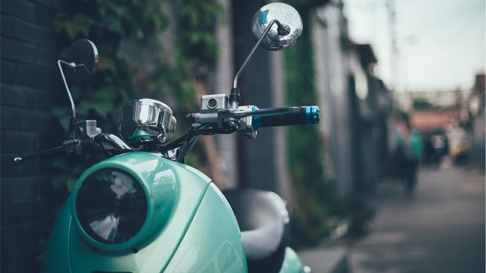 Close-up of a vintage teal scooter handlebars