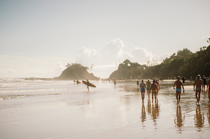 People walking on a beach with surfboards