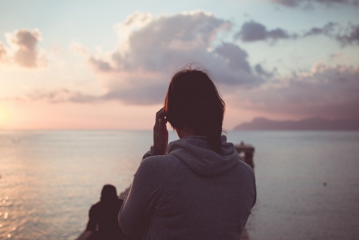 Woman looking at the sea during sunset