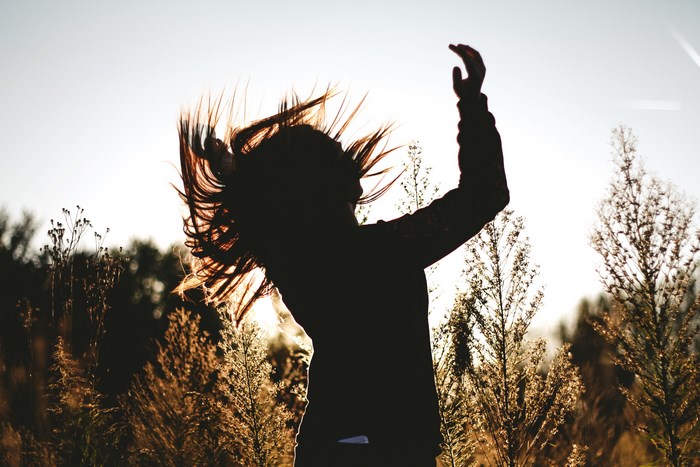 Silhouette of a woman with hair blowing in the wind