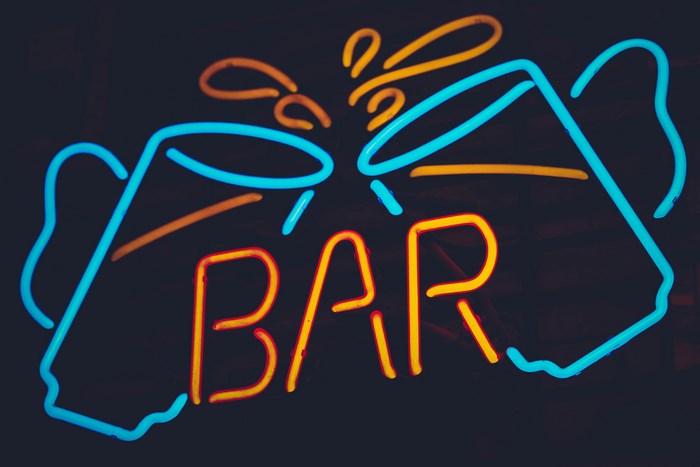 Neon bar sign with clinking glasses