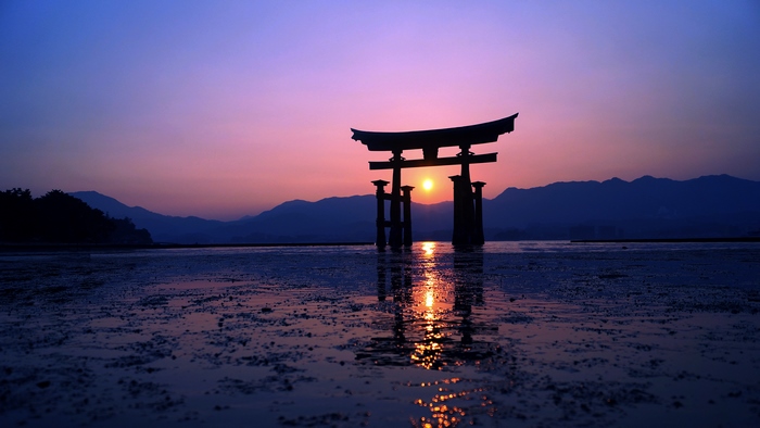 Torii gate at sunset over water