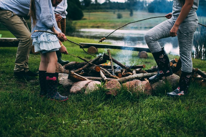 Family roasting marshmallows over a campfire
