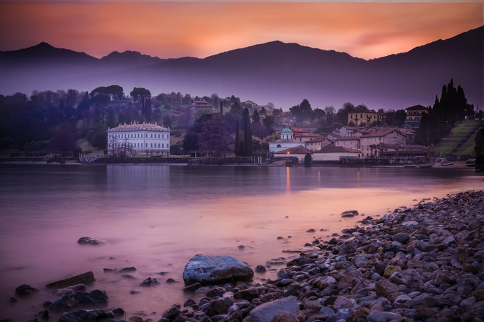 Lake Como at sunset with mountains and buildings