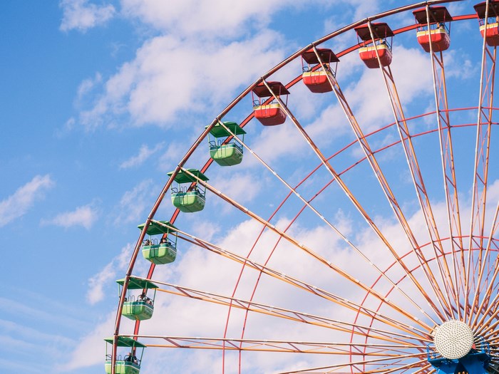 Ferris wheel against a blue sky with clouds