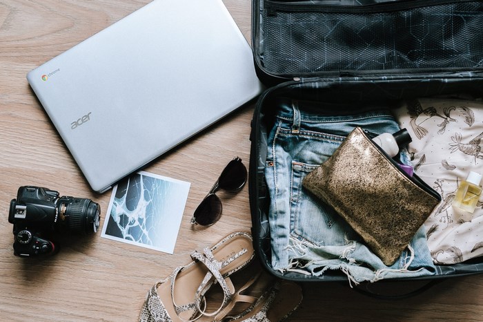 Acer Chromebook, camera, and suitcase for travel