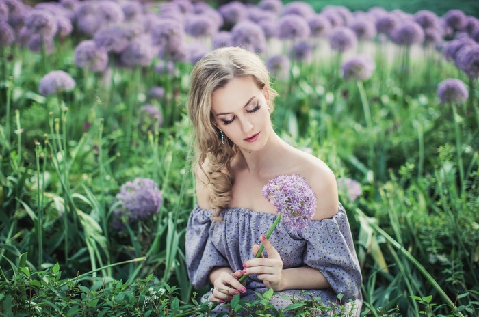 Blonde Woman Sitting in Field of Purple Flowers