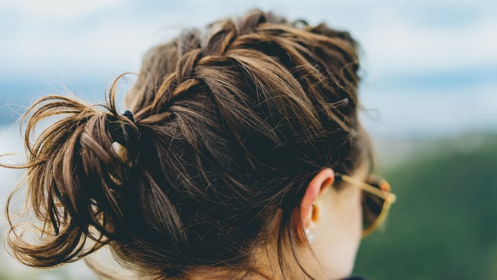 Woman with braided brown hair and sunglasses