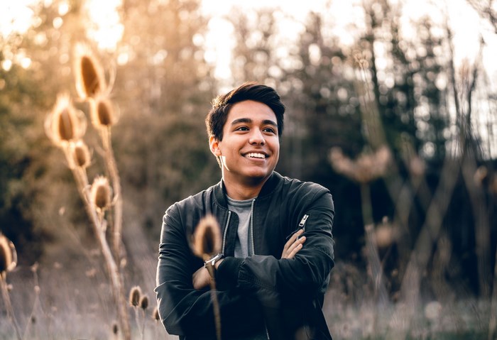 Man smiling in a field during golden hour