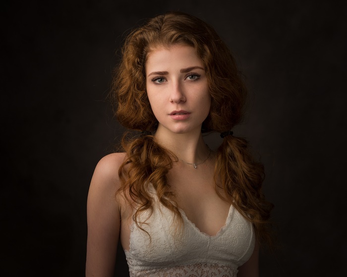 Redhead woman with pigtails wearing a white top