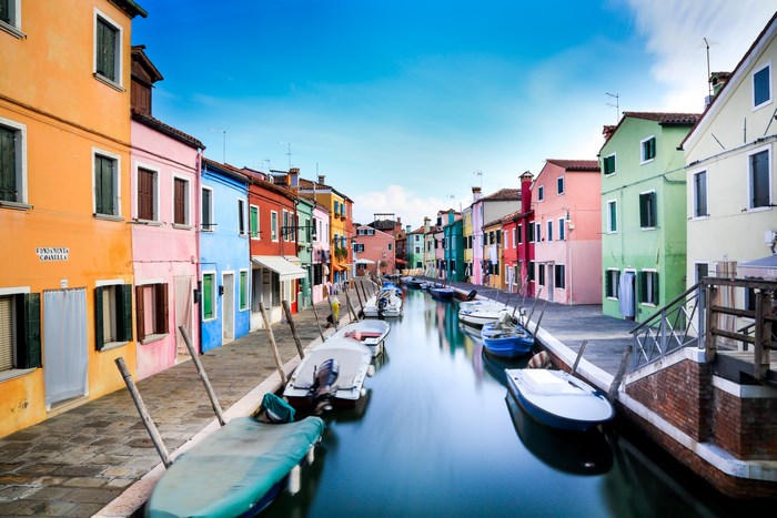 Colorful houses and boats on a canal in Burano, Italy