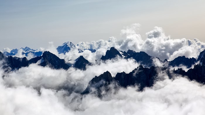 Jagged mountain peaks emerge from clouds in Chamonix, France