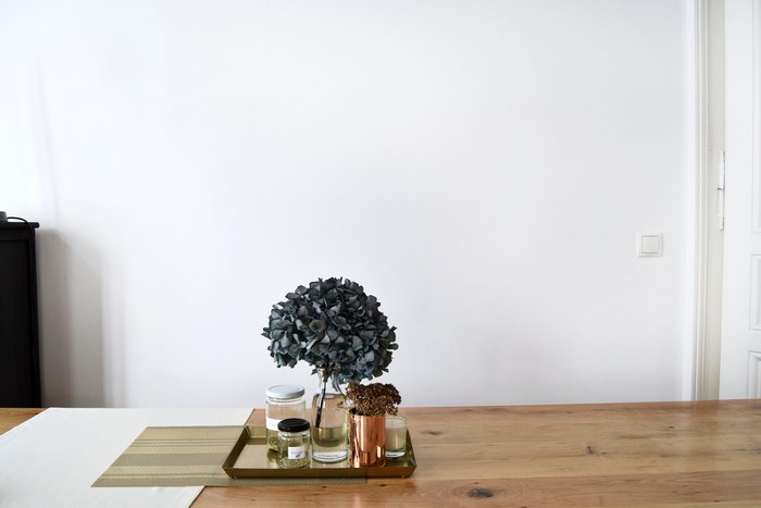 Hydrangea and jars on a golden tray on a wooden table