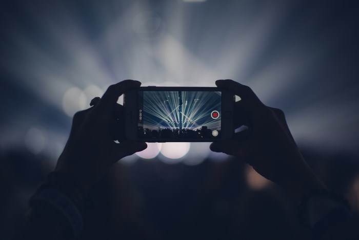 Person recording a concert with a smartphone