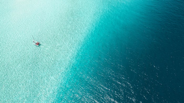 Aerial view of a sailboat on turquoise water