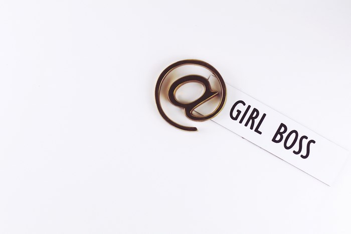 Gold "@" symbol paperclip on "GIRL BOSS" text