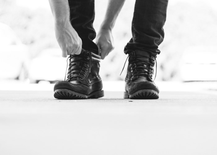 Man tying laces on black boots