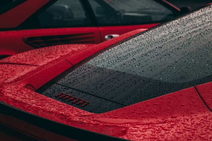 Red Ferrari with water droplets on a rainy day
