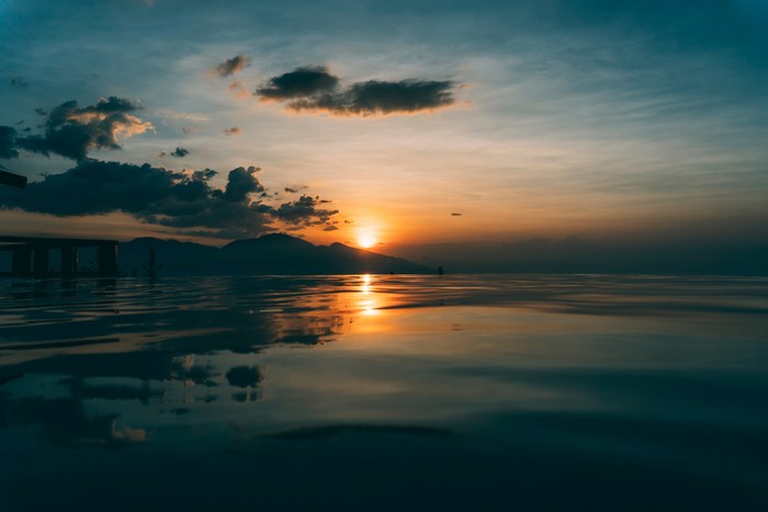 Sunset over the ocean with mountain reflection