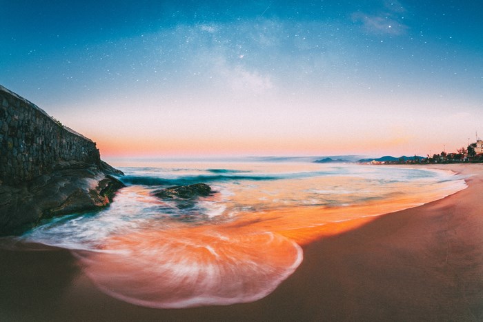 Beach at sunset with stars and ocean waves