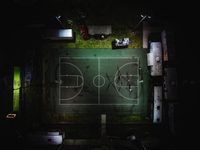 Aerial view of a basketball court at night with players