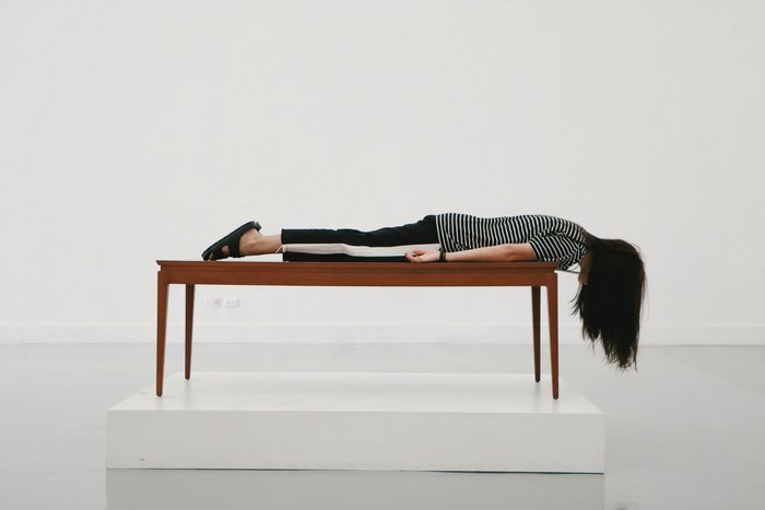Woman lying face down on a wooden table