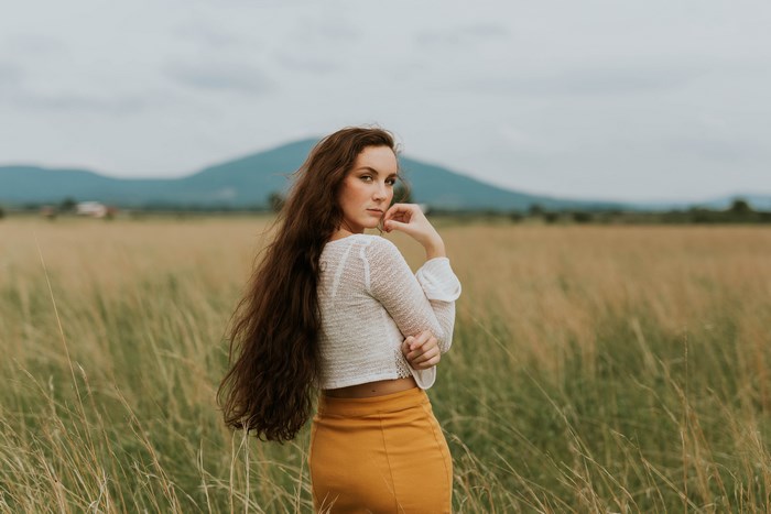 Woman in a field with long hair and a skirt