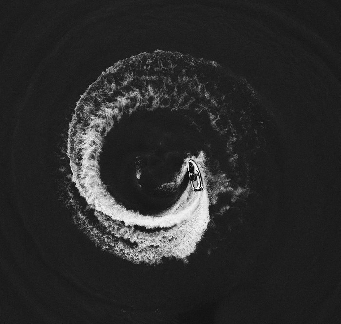 Jet ski creating a circular wake on dark water