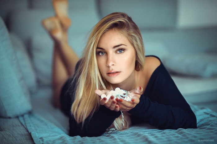 Woman with blonde hair and blue eyes holding lights