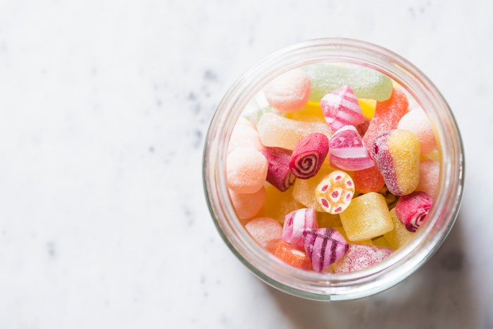 Assorted colorful candies in a glass jar