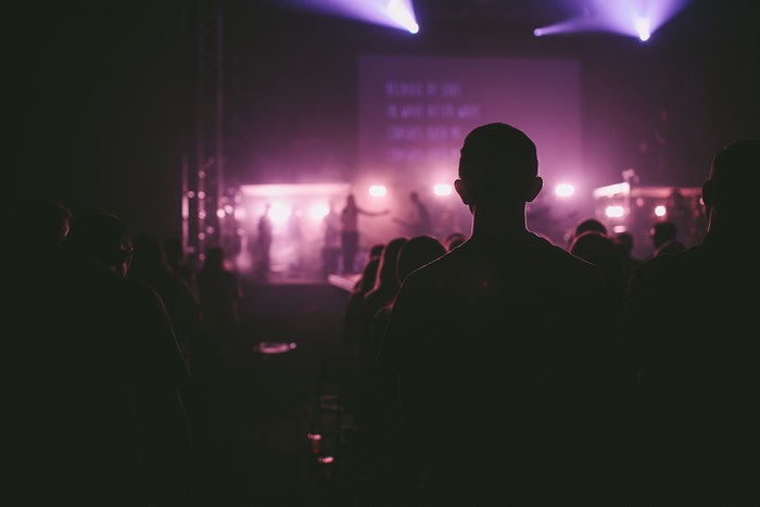 Audience watching a live music performance with purple lights