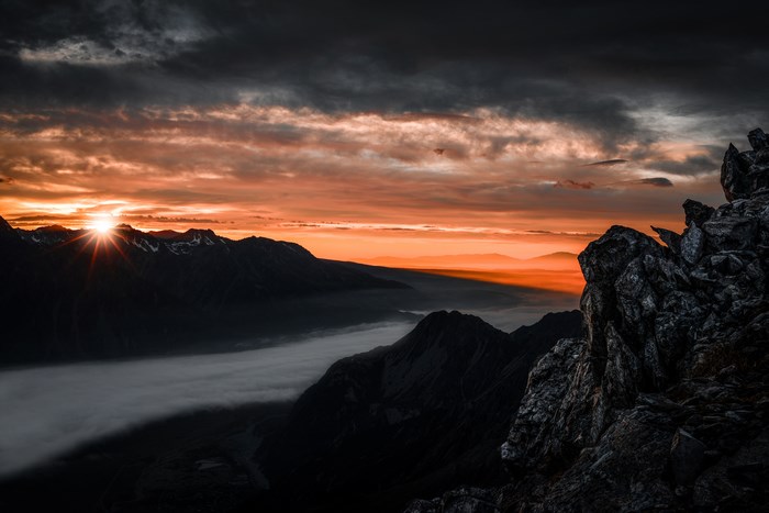 Mountain range at sunrise with fog and rocks