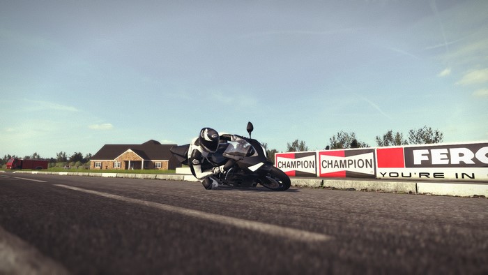 Motorcycle racer on a track with Champion banners