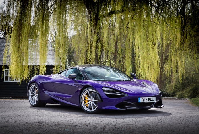 Purple McLaren 720S parked near a house with weeping willow trees