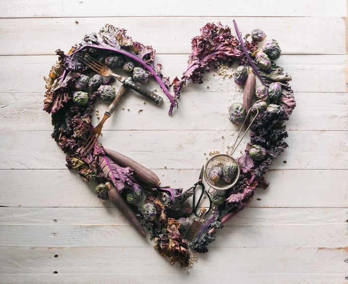 Heart-shaped arrangement of purple vegetables and utensils