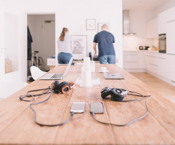 Couple working at a table with laptops and headphones