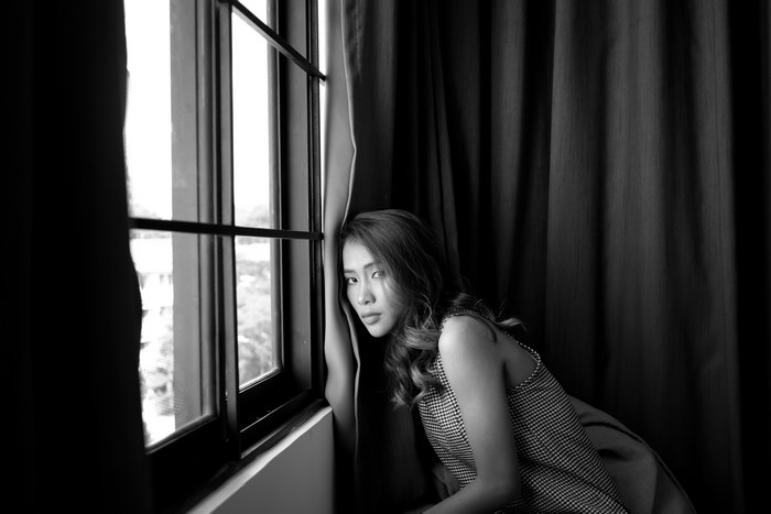 Young Asian woman leaning by a window