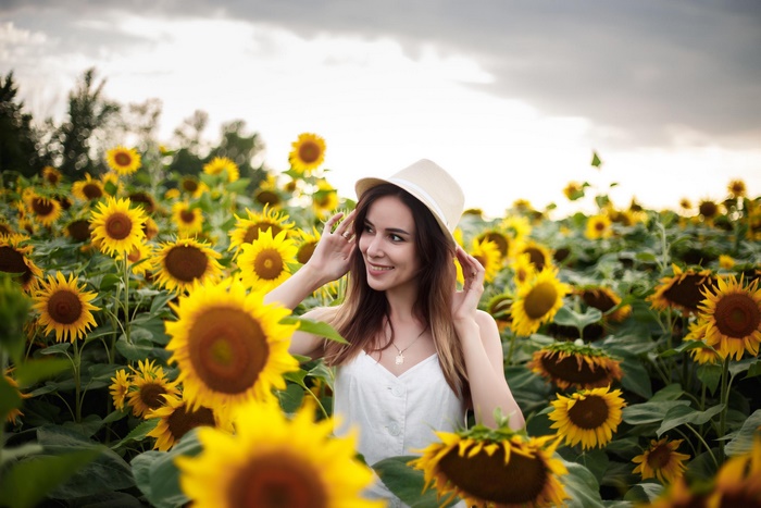Woman in a hat in a sunflower field