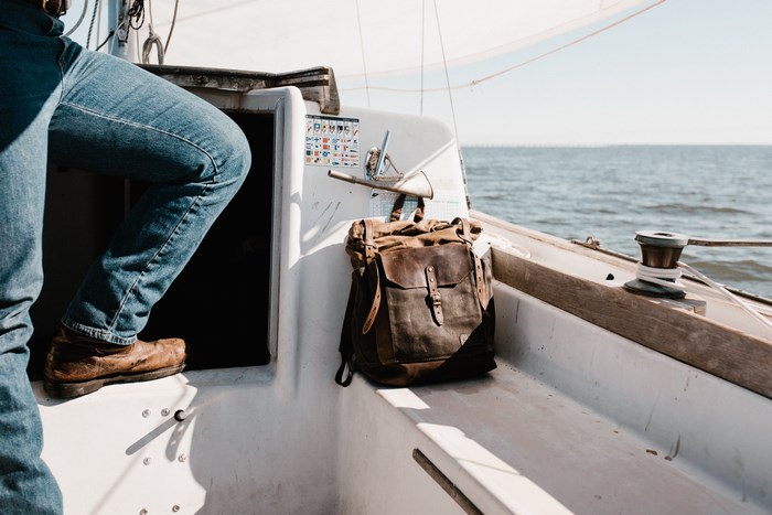 Man and backpack on a sailboat