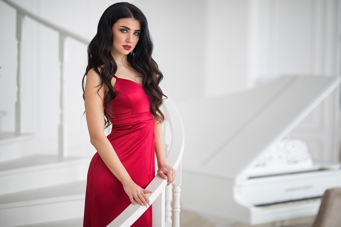 Woman in red dress by a grand piano