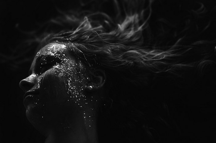 Monochrome portrait of a girl with glitter on her face