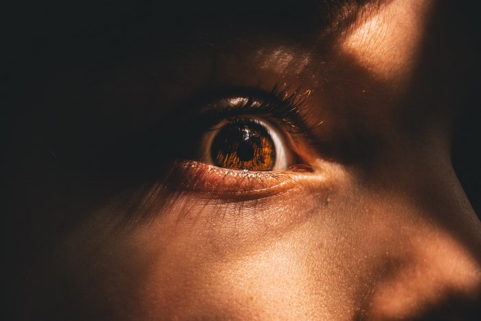 Close-up of a child's eye with sunlight and shadow