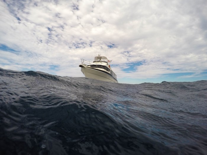 White yacht on choppy ocean under cloudy sky