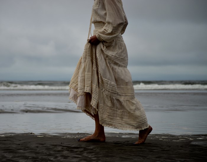 Woman in a dress walking on a beach