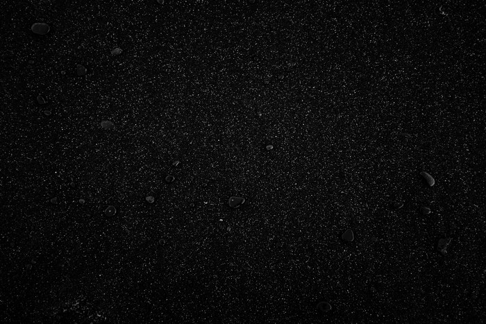Black sand with water droplets on Iceland beach