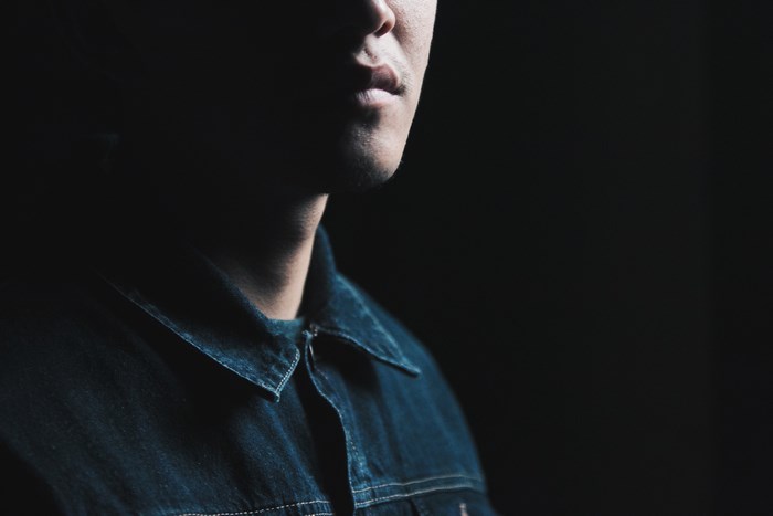 Man in denim shirt with dramatic lighting