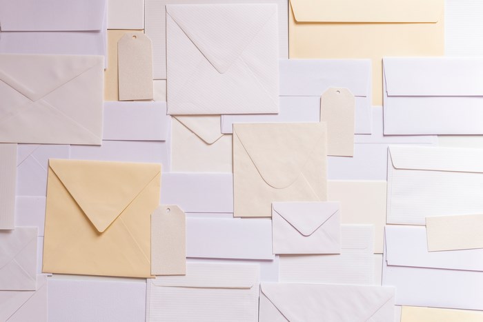 Flat lay of envelopes and tags in cream and white colors